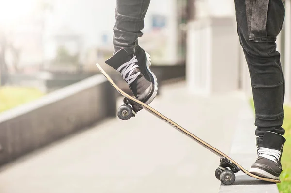 Rapaz patinador está fazendo acrobacias na rua — Fotografia de Stock