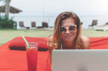 Havuzun döşeme ve onu laptop çalışan genç kadın serbest meslek.