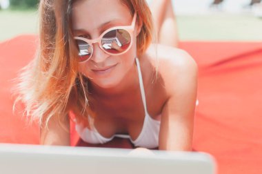 Havuzun döşeme ve onu laptop çalışan genç kadın serbest meslek.