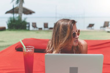 Havuzun döşeme ve onu laptop çalışan genç kadın serbest meslek.