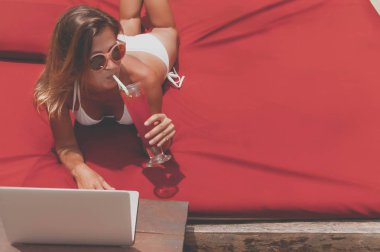 Havuzun döşeme ve onu laptop çalışan genç kadın serbest meslek.