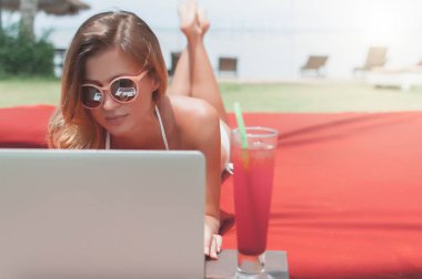 Havuzun döşeme ve onu laptop çalışan genç kadın serbest meslek.