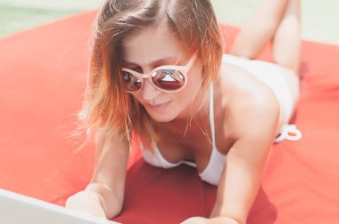 Havuzun döşeme ve onu laptop çalışan genç kadın serbest meslek.