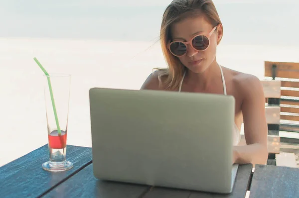 Жінка працює на пляжі з ноутбуком — стокове фото