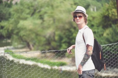 Genç şık adam Gürcistan'daki tahta köprüden karşıya