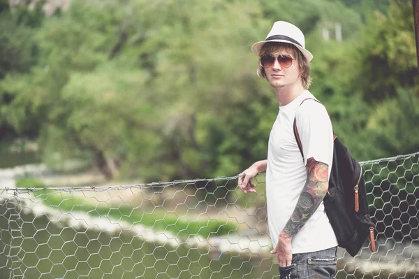 Genç şık adam Gürcistan'daki tahta köprüden karşıya