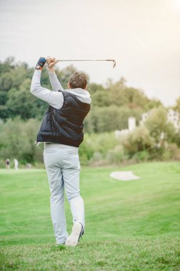 Golf sahasında golf oynayan adam.