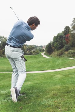 Golf sahasında golf oynayan adam.