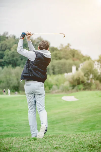 Golf sahasında golf oynayan adam.