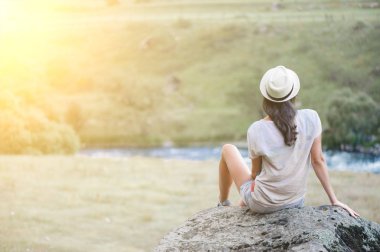 Genç kadın siiting açık havada Taştaki ve rahatla