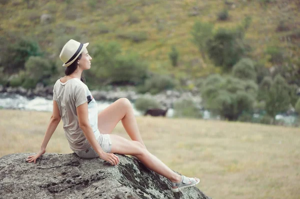 Siiting młoda kobieta na kamieniu na zewnątrz i relaks — Zdjęcie stockowe