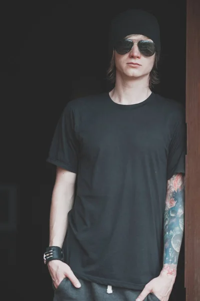 Şık adam giyen siyah gömlek, siyah arka plan portresi.