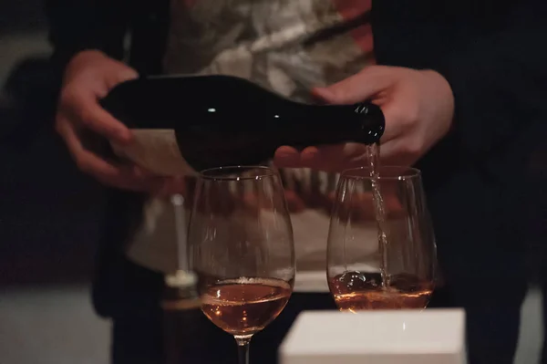 赤ワインを長茎ワイングラスに注ぐ男性ソムリエ. — ストック写真