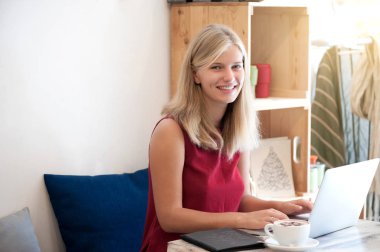 Kafede dizüstü bilgisayar yazmaya genç kadın serbest meslek