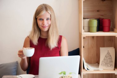 Kafede dizüstü bilgisayar yazmaya genç kadın serbest meslek