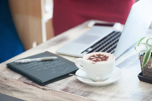 Junge Freiberuflerin tippt in Laptop in Café — Stockfoto