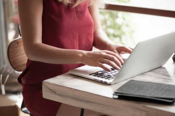 Junge Freiberuflerin tippt in Laptop in Café — Stockfoto