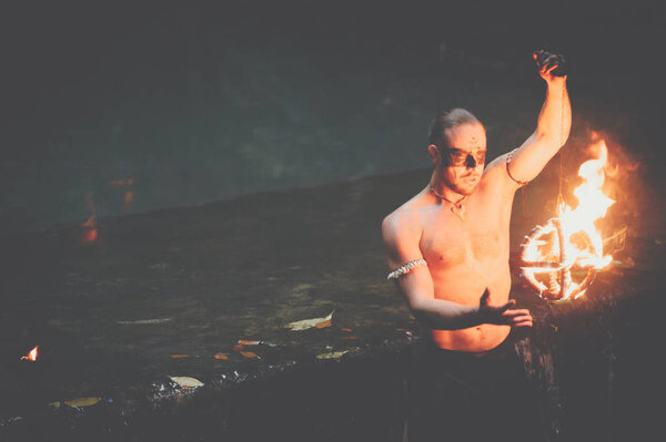 Awesome fire show at the waterfall. Brutal muscle man