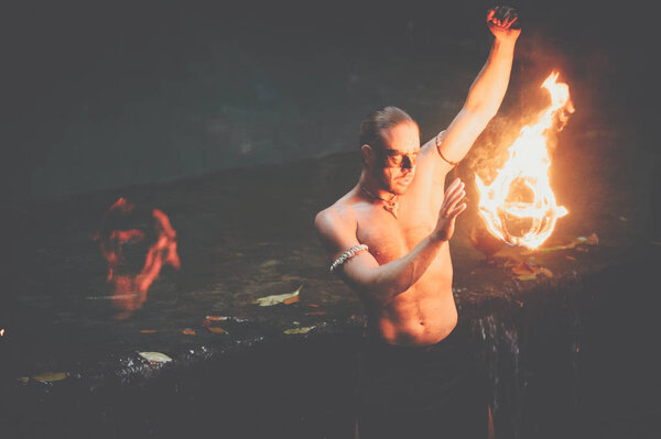 Awesome fire show at the waterfall. Brutal muscle man