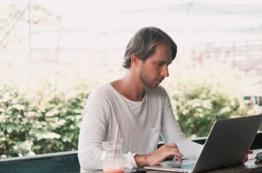 İçinde laptop çalışma kafede oturan genç erkek serbest meslek