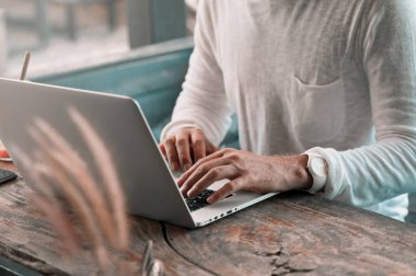 İçinde laptop çalışma kafede oturan genç erkek serbest meslek