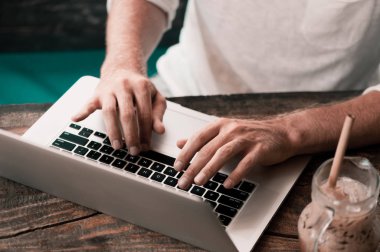 İçinde laptop çalışma kafede oturan genç erkek serbest meslek
