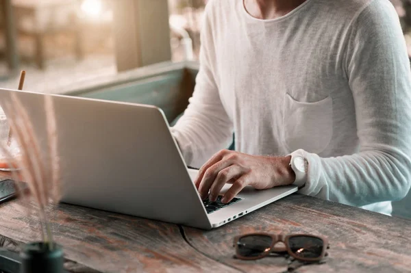 İçinde laptop çalışma kafede oturan genç erkek serbest meslek