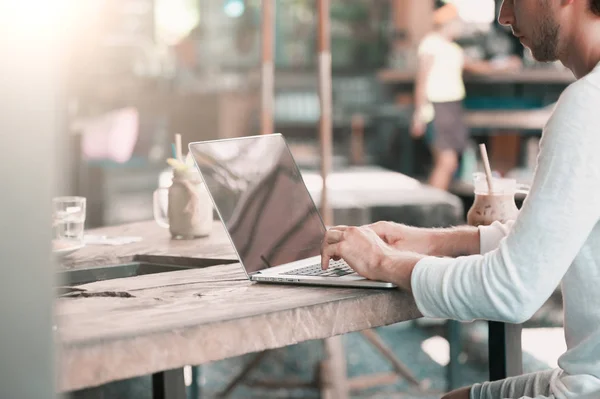 Giovane freelance di sesso maschile seduto in un caffè che lavora in un computer portatile — Foto Stock