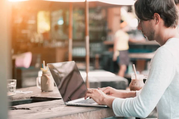 Jeune pigiste masculin assis dans un café travaillant dans un ordinateur portable — Photo