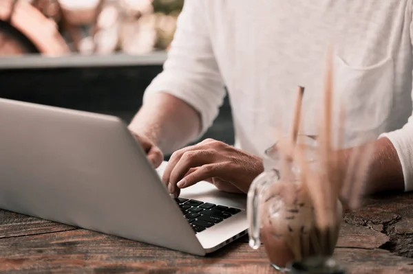 Jeune pigiste masculin assis dans un café travaillant dans un ordinateur portable — Photo