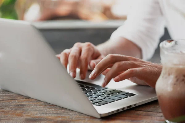 Junger männlicher Freiberufler sitzt im Café und arbeitet im Laptop — Stockfoto