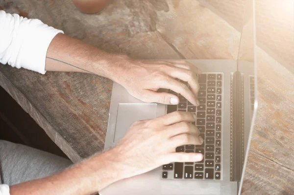 Junger männlicher Freiberufler sitzt im Café und arbeitet im Laptop — Stockfoto