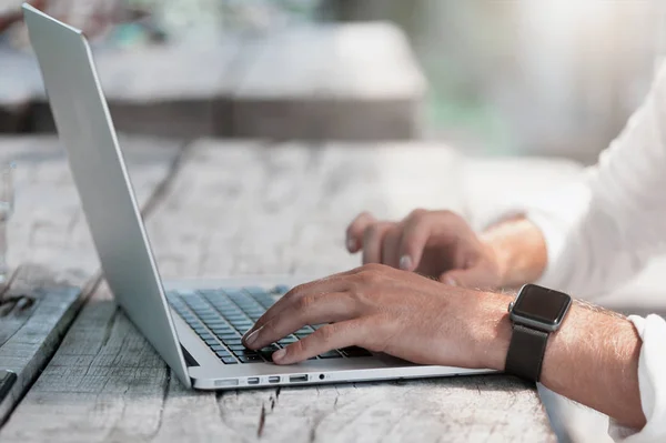 Joven freelancer sentado en la cafetería trabajando en el portátil — Foto de Stock