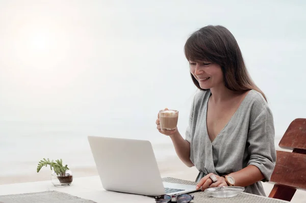 Щаслива жінка використовує ноутбук у кафе . — стокове фото