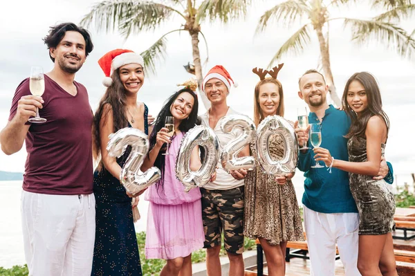 Amis célébrant Noël ou Nouvel An à la plage . — Photo