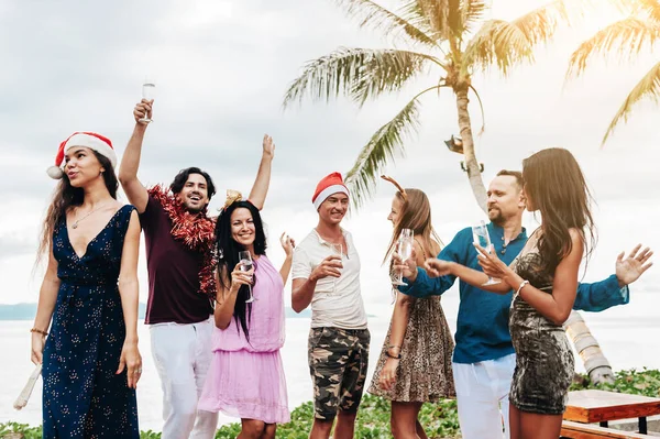 ビーチでクリスマスや新年の前夜を祝う友人. — ストック写真