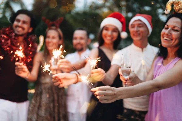Vänner som firar jul med glitter och champagne — Stockfoto