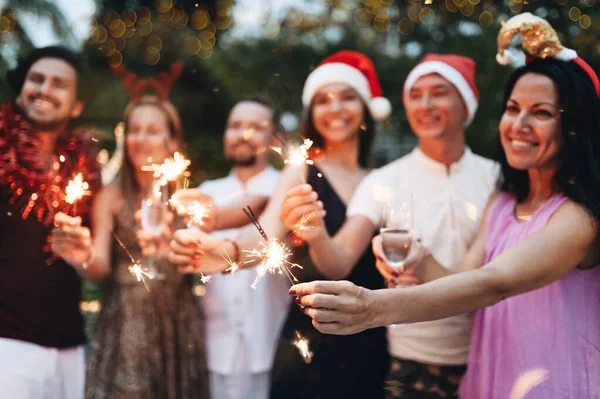 Grupo de amigos comemorando o Natal com brilhos e champanhe — Fotografia de Stock