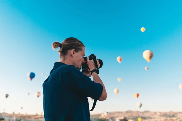 Pemuda fotografer membuat gambar balon udara saat matahari terbit di Kapadokia — Stok Foto