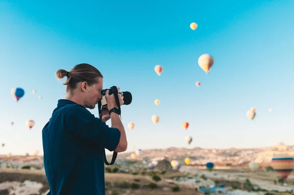 Młody fotograf robi zdjęcia balonów o wschodzie słońca w Kapadocji — Zdjęcie stockowe