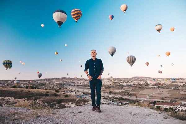 Jovem em férias na Turquia Capadócia olhando para os balões de ar durante o nascer do sol em Kapadokya — Fotografia de Stock