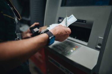 ATM kartı ve ATM kartı kullanarak erkek eli kapat.