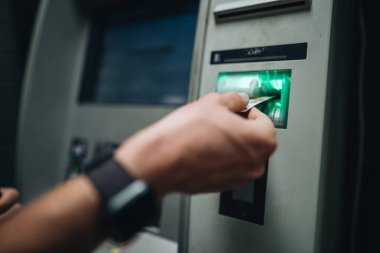 ATM kartı ve ATM kartı kullanarak erkek eli kapat.