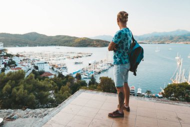 Fethiye limanına bakan yakışıklı sarışın bir adam.