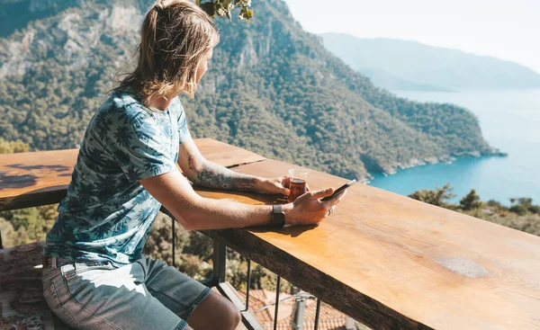 Homem sentado no café com bela vista e bebendo chá turco tradicional . — Fotografia de Stock