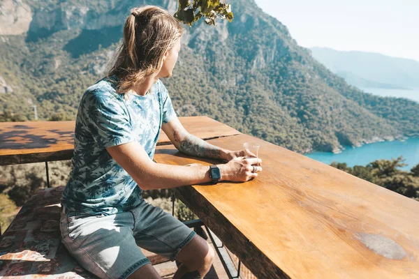 Homem sentado no café com bela vista e bebendo chá turco tradicional . — Fotografia de Stock