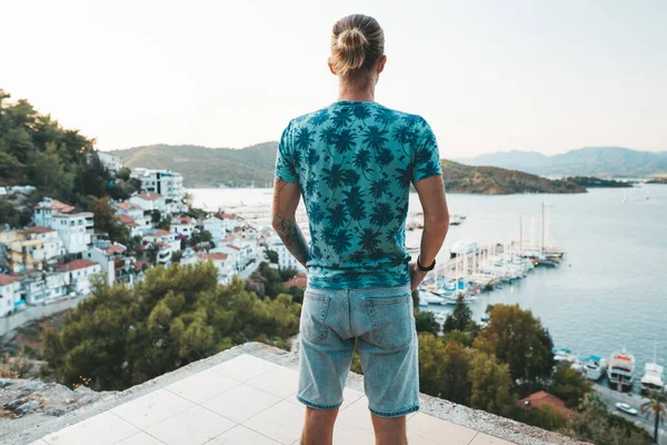 Przystojny blondyn stoi w punkcie widokowym z widokiem na port w Fethiye — Zdjęcie stockowe