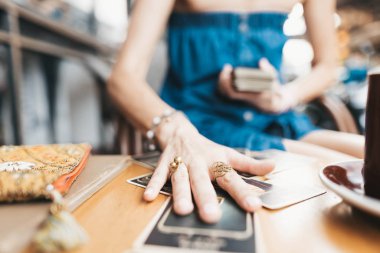 Kadın kafede masada Tarot kartları okuyor.