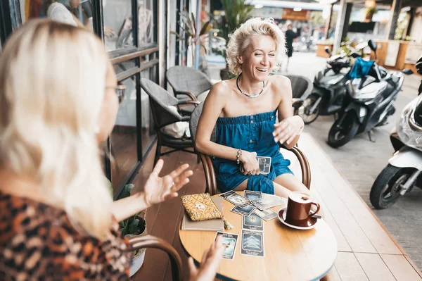 Vrouw leest Tarot kaarten op tafel in café — Stockfoto