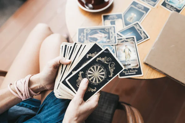 Mulher está lendo cartas de tarô na mesa no café — Fotografia de Stock